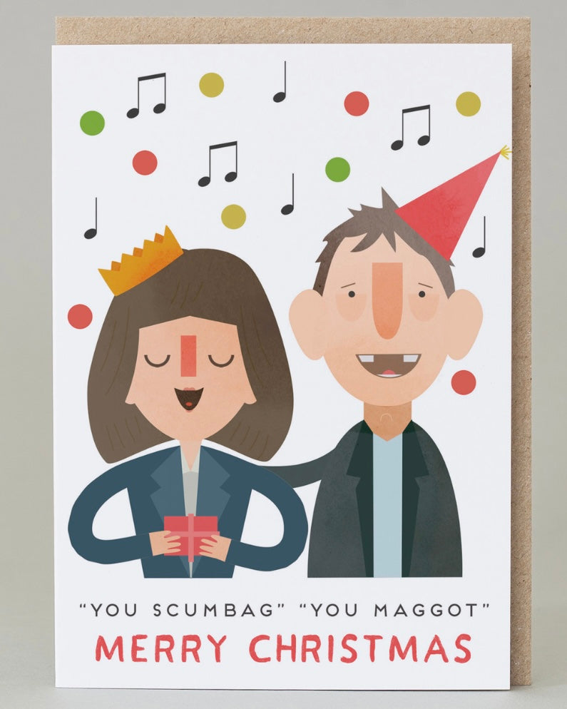 Illustrated Christmas card with cartoon characters of Shane MacGowan and Kirsty MacColl and festive text on a white background.