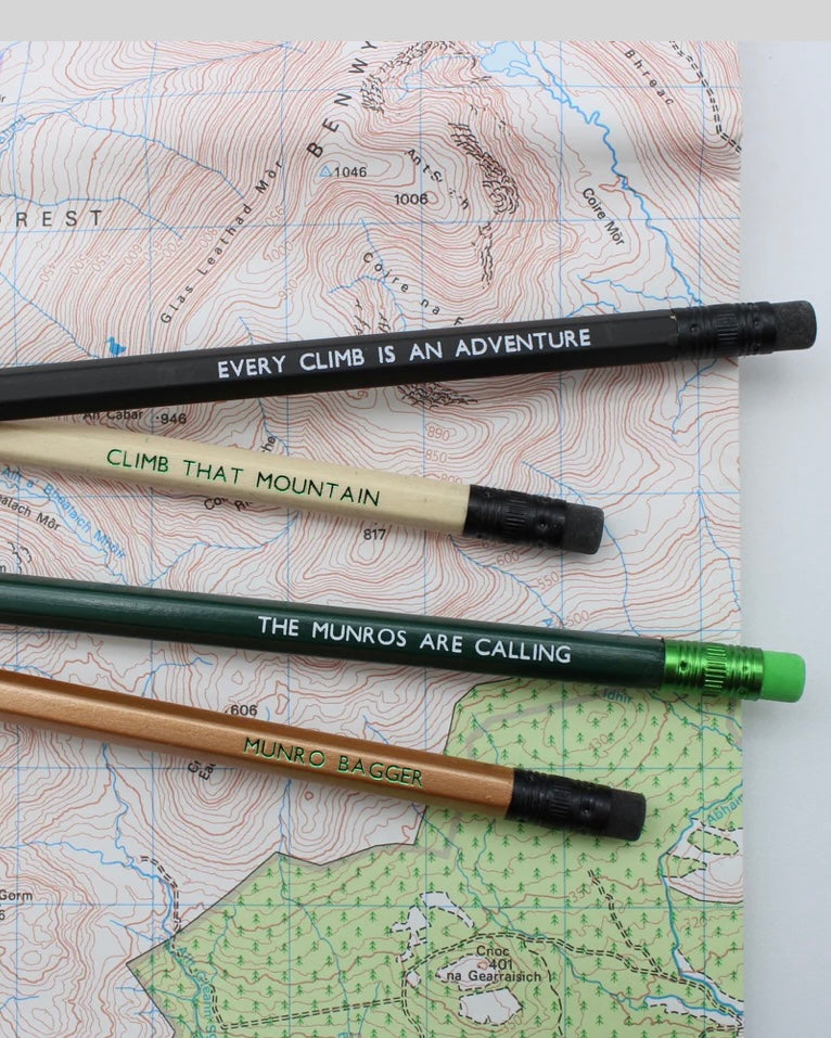 Four pencils with motivational Scottish Munro themed phrases on a topographic map.
