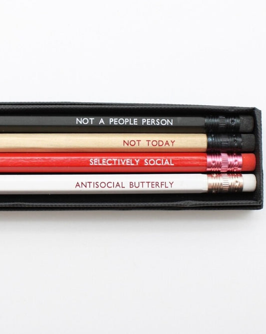 Set of pencils with humorous phrases in a black cardboard box on a white background