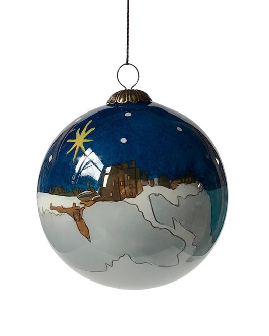 A handpainted glass bauble with a snowy night-time Dunnottar Castle scene, featuring a star in the sky and snow-covered ground.