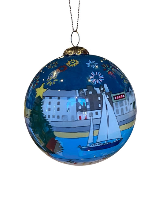 Handpainted glass bauble with a Christmas depiction of a Stonehaven Harbour scene with buildings and a boat, in blue and other colors, with a gold hanging loop.