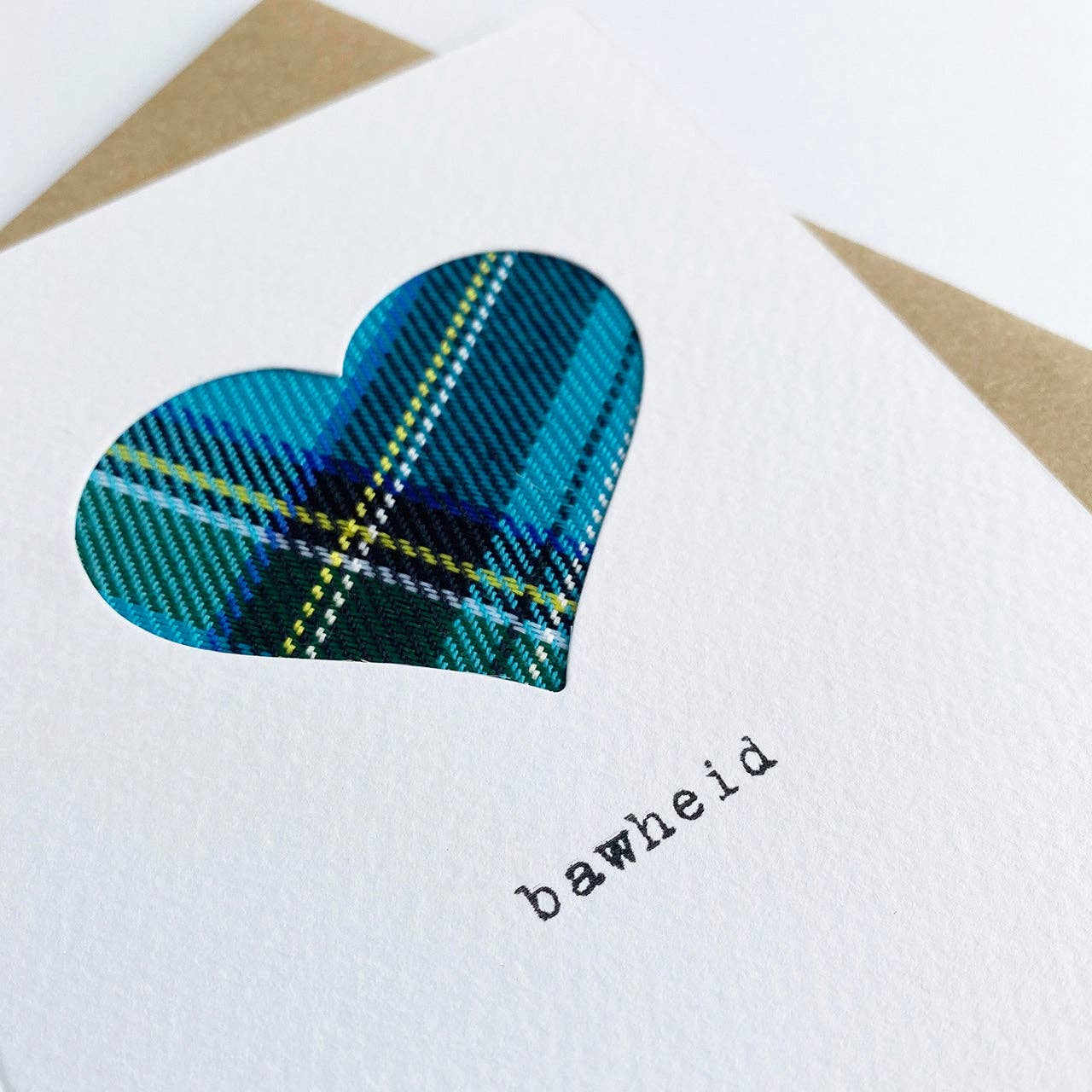 Heart-shaped real cloth blue tartan design on a white card with 'bawheid’ text.