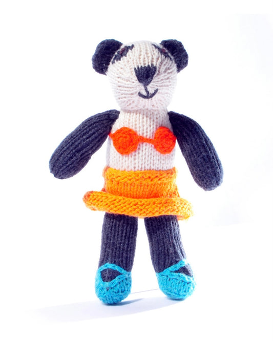 Knitted toy panda with an orange bikini and skirt, on a white background