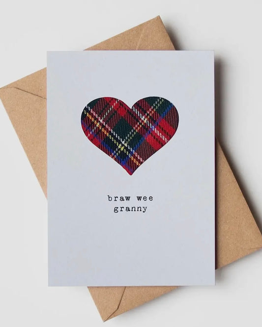 Card with real cloth tartan heart and text 'braw wee granny' on a white background with a brown envelope.
