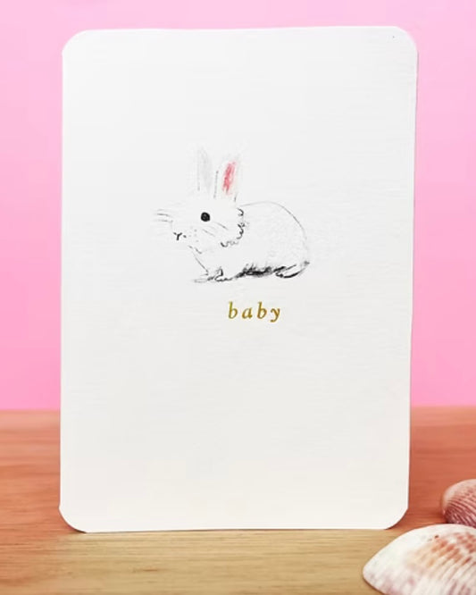 Greeting card with a rabbit illustration and 'baby' text on a pink background