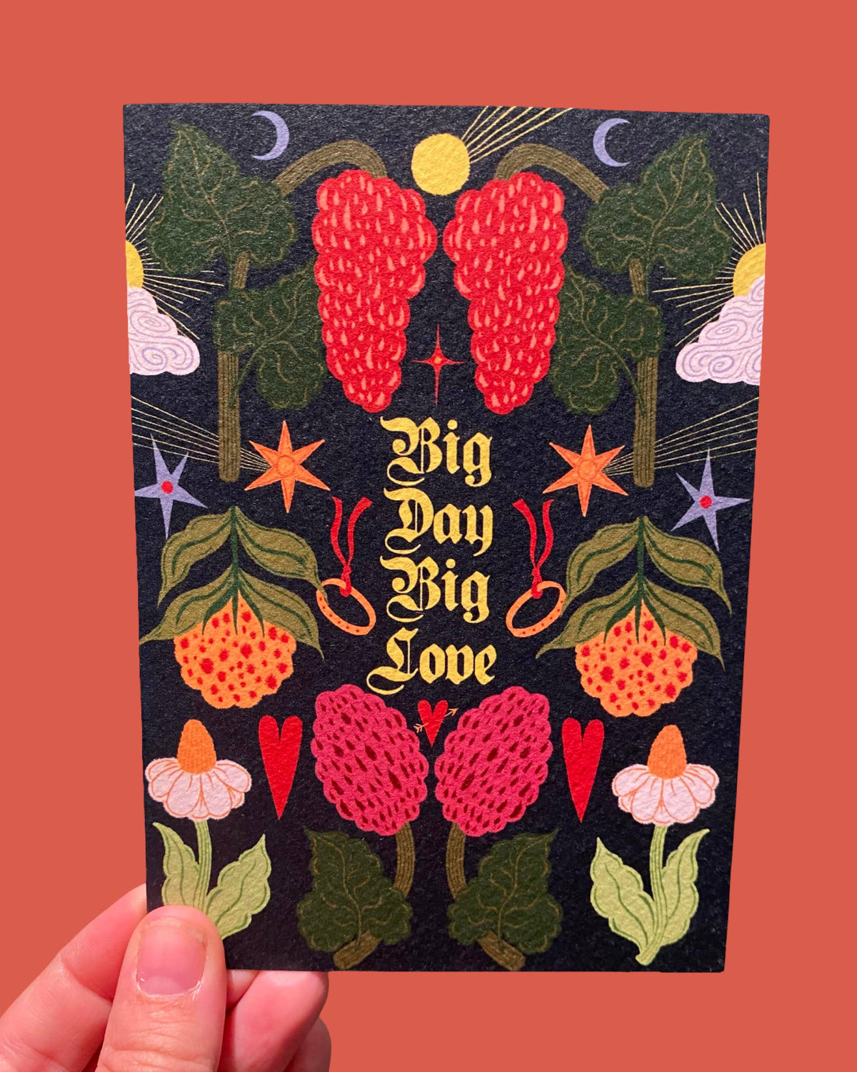 Card with colorful design and 'Big Day Big Love' text held against a red background
