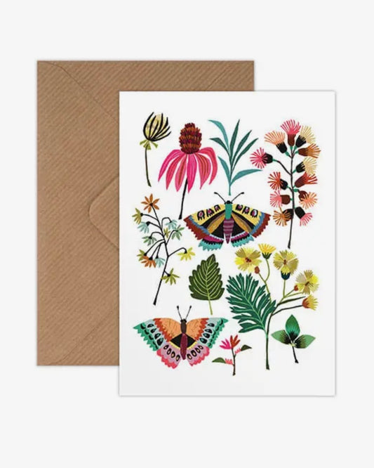 Greeting card with colourful floral and butterfly design on a white background, accompanied by a brown envelope.