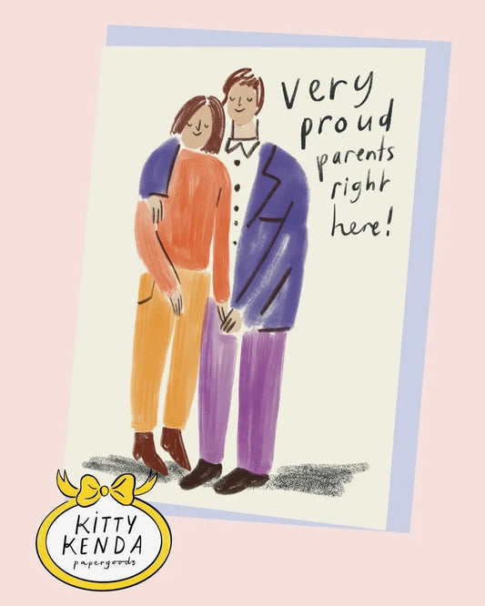 Card with illustration of two people holding hands and text 'Very proud parents right here!' by Kitty Kenda.
