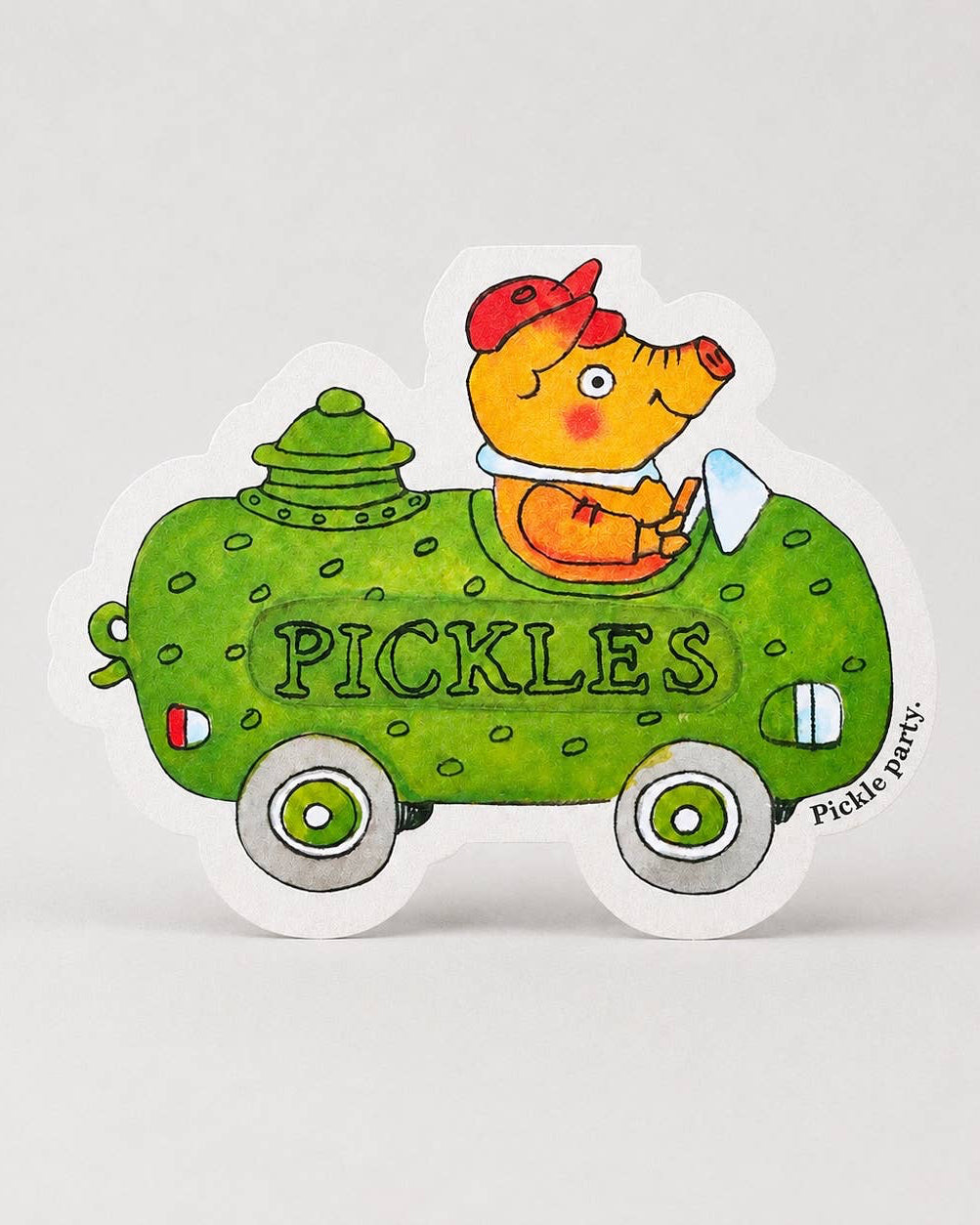 Shaped card of a Richard Scarry pig driving a green pickle-shaped car  with the words ‘Pickle party’ on a white background