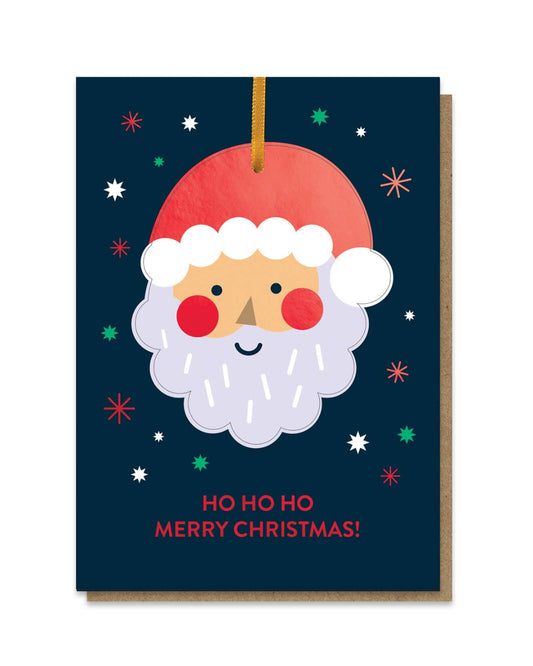 Christmas card with a cartoon Santa Claus face on a dark blue background with colourful stars.