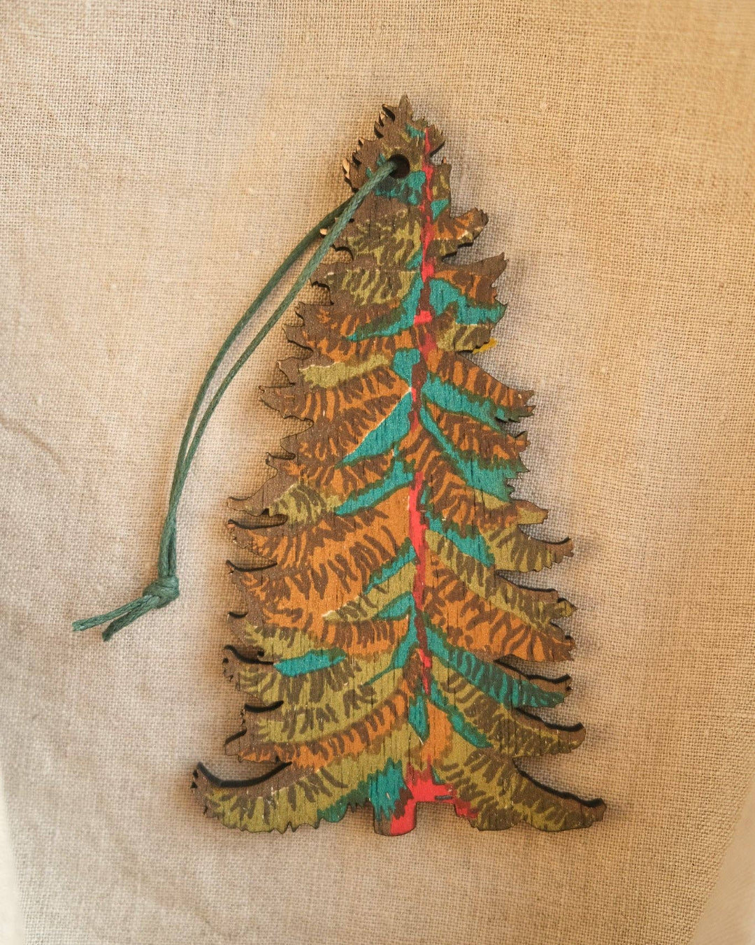 Decorative Christmas tree ornament on a textured beige background