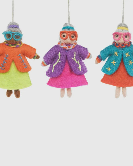 Three colourful felt hanging Groovy Granny dolls with winter accessories on a white background