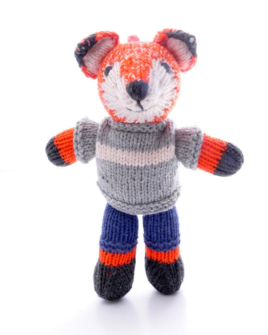 Knitted toy fox with a grey sweater with white stripe, on a white background.