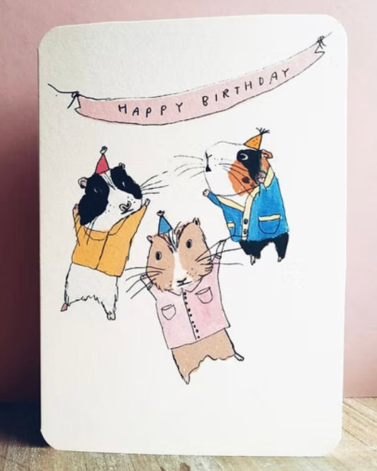 Birthday card with cartoon guinea pigs wearing party hats and a 'Happy Birthday' banner.