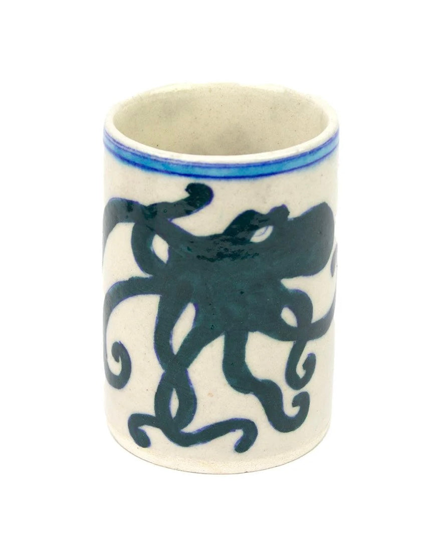 Ceramic cup with blue octopus design on a white background