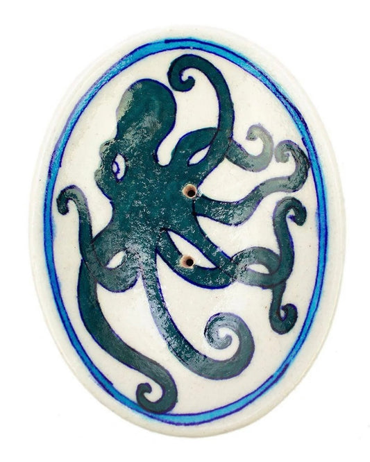 Ceramic soap dish with a painted blue octopus design on a white background