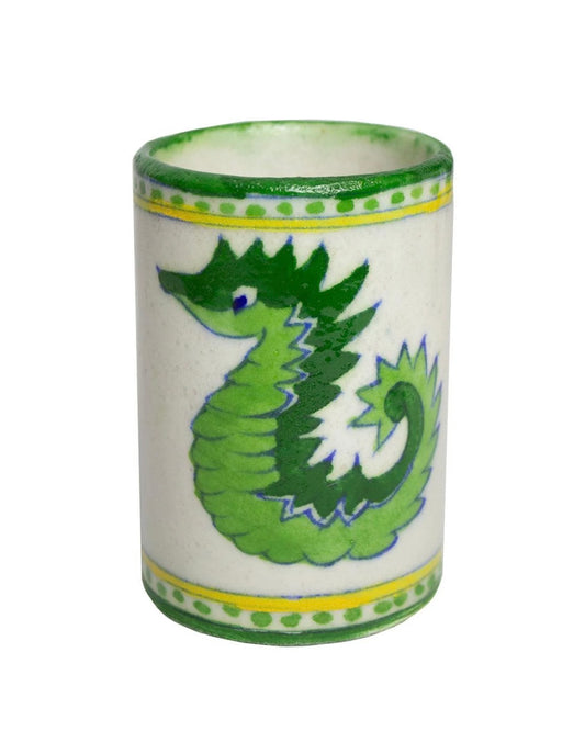 Ceramic tumbler with green seahorse design on a white background