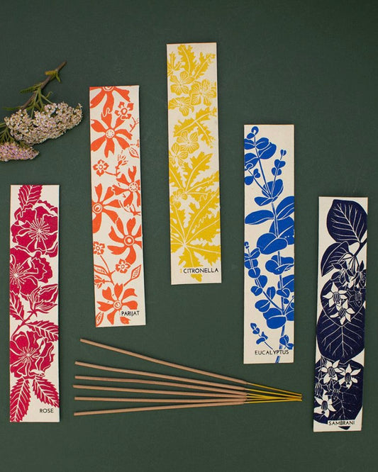Set of floral and leaf-patterned packets of incense sticks, on a dark background