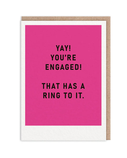 Pink block colour card with black text ‘Yay! You’re Engaged! That has a ring to it’, on a white background