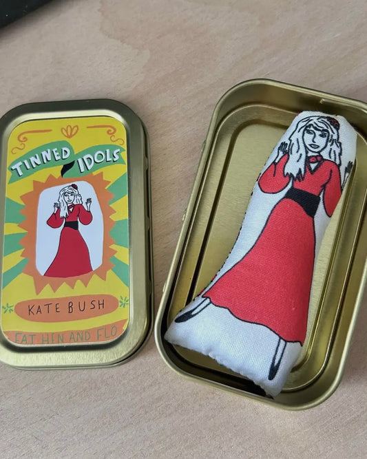 Tin with a mini plush toy of Kate Bush in a red dress and the label 'Tinned Idols Kate Bush'.