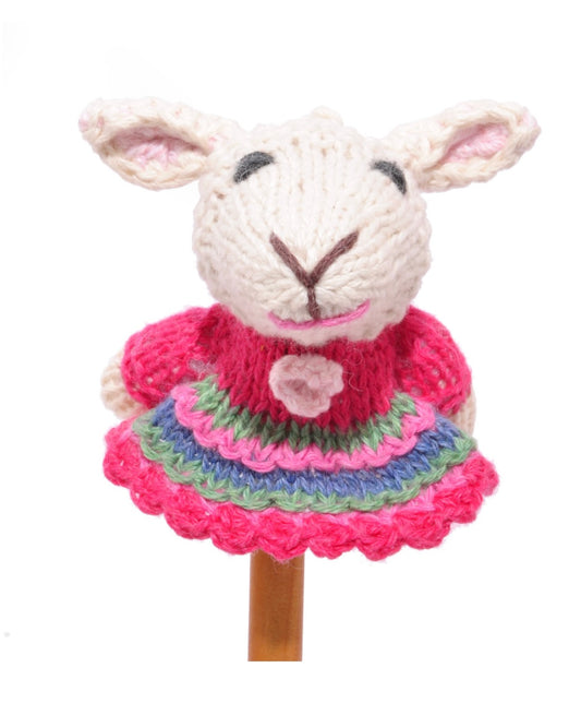 Knitted sheep finger puppet with a pink dress, on a white background.