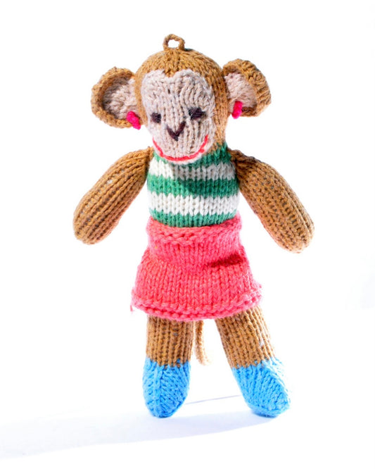 Knitted monkey toy with a striped top and pink skirt, on a white background