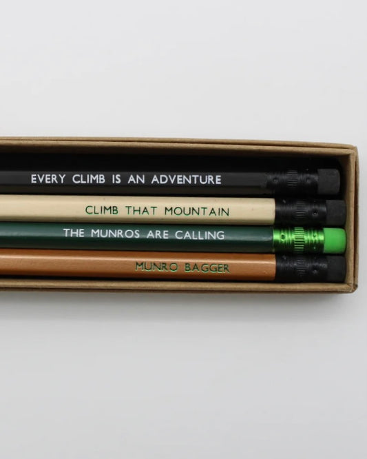 Set of hiking pencils with motivational phrases in a box on a light gray background