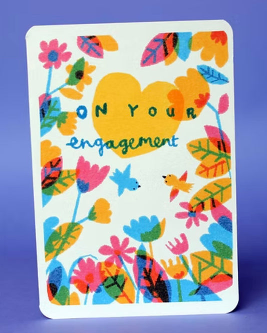 Colourful  card with floral patterns and 'On Your Engagement' text. Card is on a purple background.