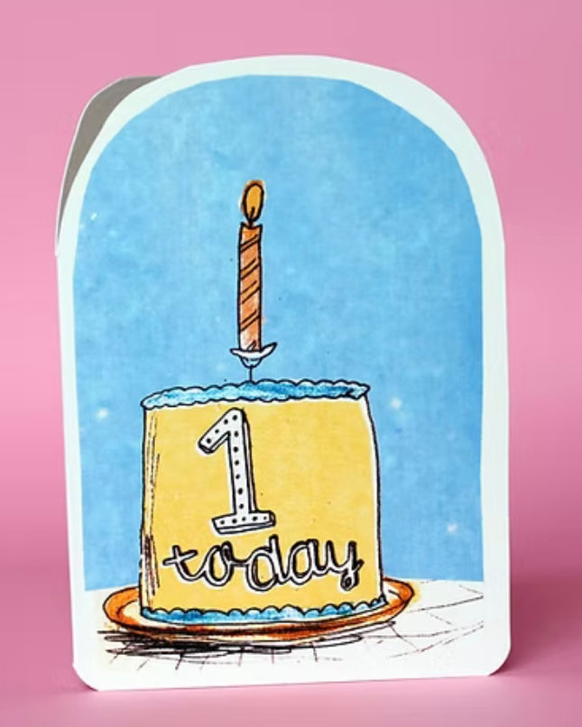 Card with a birthday cake and 1 candle on a pink background