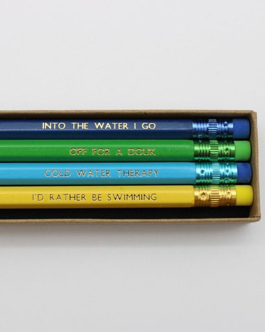 Set of four pencils with different sayings about Open Water Swimming in a box on a white background