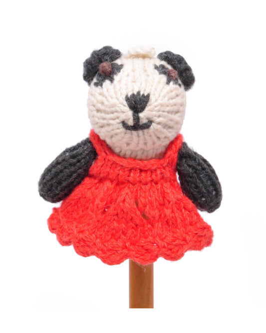 Knitted panda finger puppet toy with a red dress, on a white background