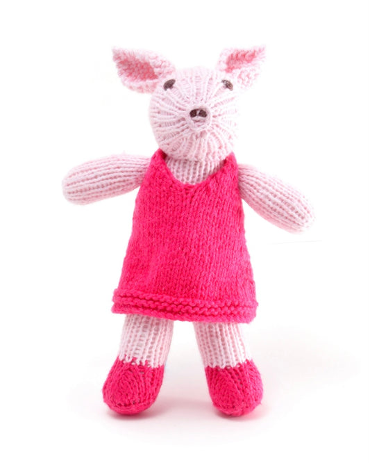 Knitted toy pig in a pink dress, on a white background