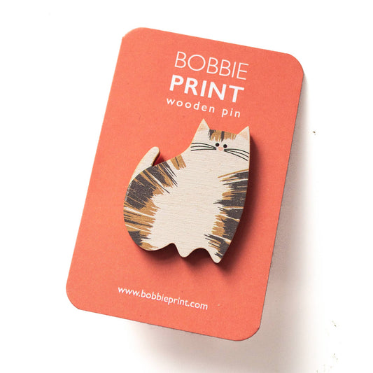 Cat-shaped wooden pin on a red card with 'Bobbie Print' branding