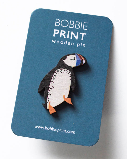 Puffin-shaped wooden pin on a blue card with 'Bobbie Print' branding.
