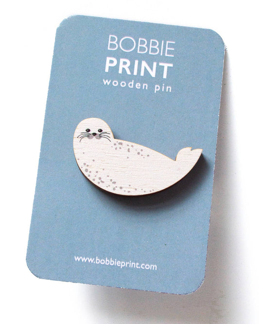 Wooden seal pin on a blue card with 'Bobbie Print' branding