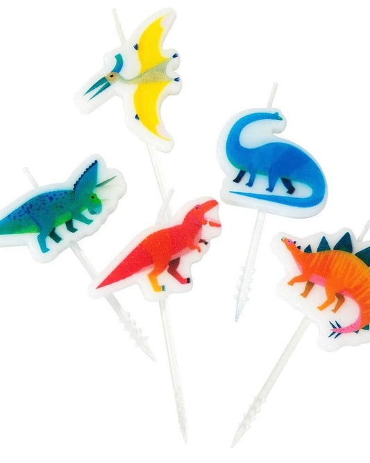 Set of colorful dinosaur-themed cake candles on sticks against a white background