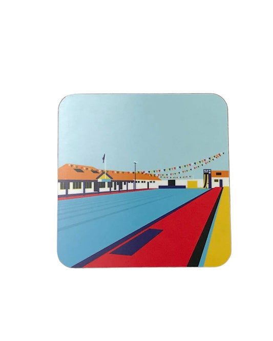 Square coaster featuring a colourful graphic illustration of Stonehaven Open Air Pool, on a white background.