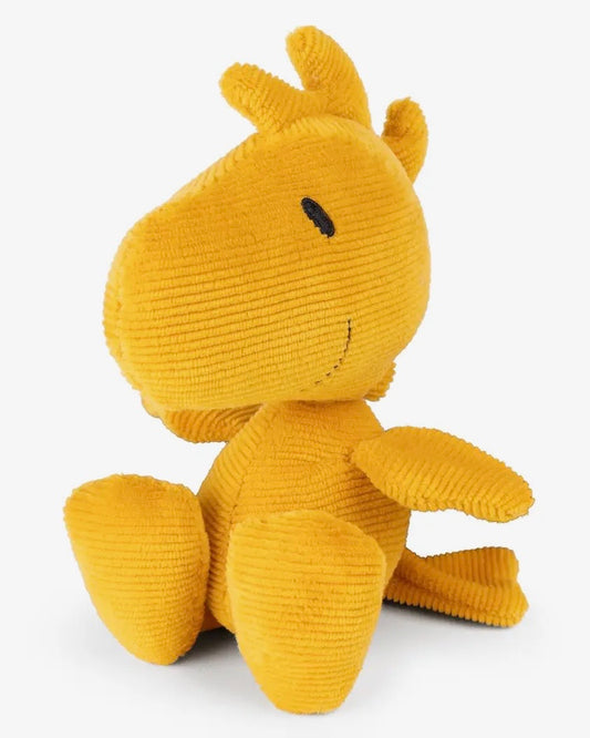 Yellow plush toy, Woodstock from Peanuts, with a smiling face on a white background
