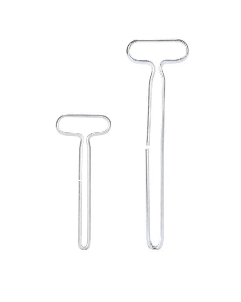 Two metal T-shaped tube squeezer tools on a white background
